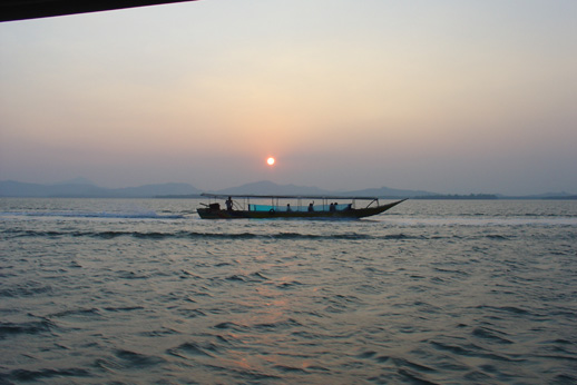 longtailing boat i solnedgång
